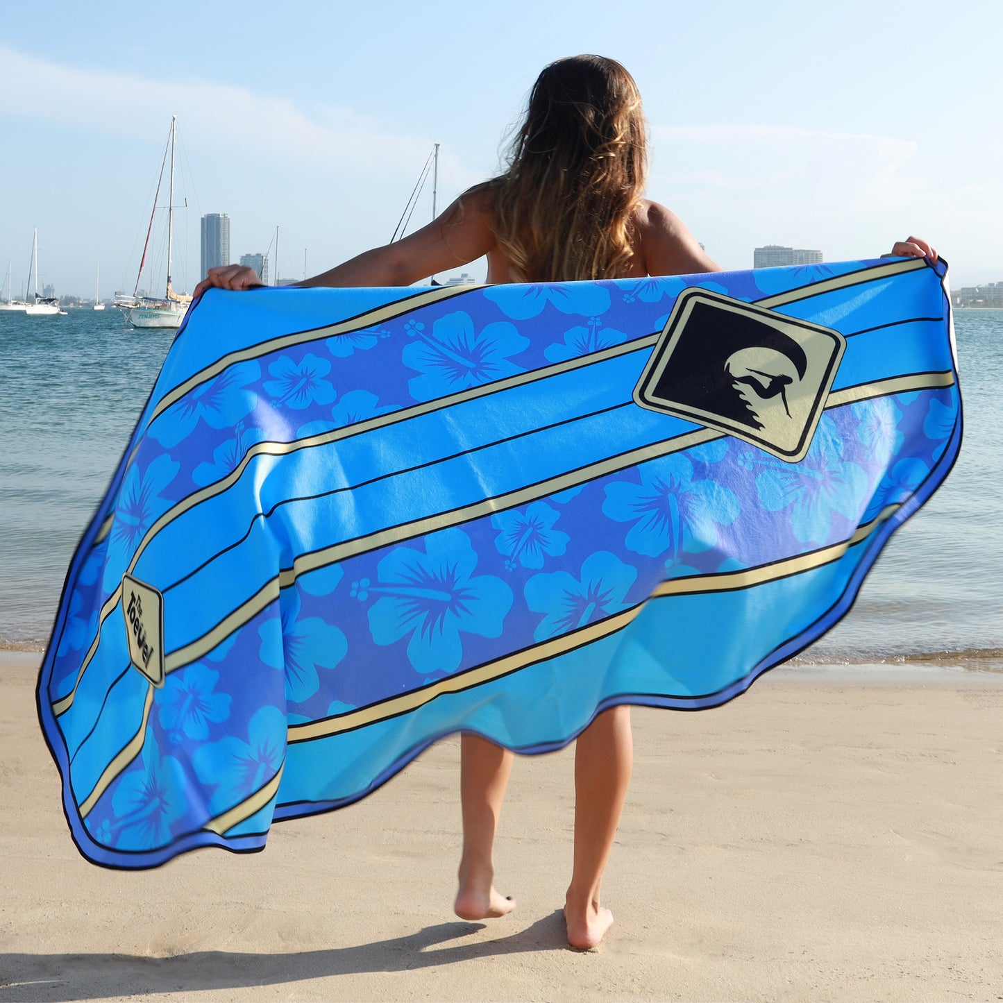 Woman showing a Blue surfboard shaped beach towel